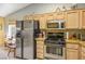 Well-lit kitchen featuring stainless steel appliances, wooden cabinetry, and granite countertops at 2137 Point Mallard Dr, Henderson, NV 89012