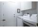A laundry room with a washer, a dryer and white cabinets at 2137 Point Mallard Dr, Henderson, NV 89012