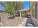 Backyard featuring rock landscaping, covered patio, and mature trees at 2213 Carrier Dove Way, North Las Vegas, NV 89084