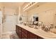 Bright bathroom featuring a large vanity, dual sinks, and a glass shower at 2213 Carrier Dove Way, North Las Vegas, NV 89084