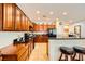 A well-designed kitchen features wood cabinetry, a breakfast bar, and tile flooring at 2213 Carrier Dove Way, North Las Vegas, NV 89084