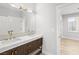 Bathroom featuring dual sinks with marble counters, dark wood cabinets, and gold hardware at 2236 Timber Rose Dr, Las Vegas, NV 89134
