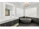 Bathroom with a freestanding tub, dual sink vanity, modern fixtures, and custom glass shower at 2236 Timber Rose Dr, Las Vegas, NV 89134