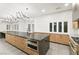 Modern kitchen with wood cabinets, stainless steel appliances, and a large island with a black countertop at 2236 Timber Rose Dr, Las Vegas, NV 89134