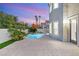 Backyard pool and spa with lush tropical landscaping and privacy wall at dusk at 2236 Timber Rose Dr, Las Vegas, NV 89134