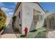 Side view of house exterior with air conditioning, fire hydrant, and low-maintenance synthetic grass at 2301 Jean Paul Ave, North Las Vegas, NV 89031