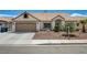 Attractive single-story home with desert landscaping, a two-car garage, and an American flag flying overhead at 2301 Jean Paul Ave, North Las Vegas, NV 89031