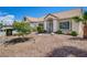 Inviting single-story home boasting a well-maintained front yard with desert landscaping and mature trees at 2301 Jean Paul Ave, North Las Vegas, NV 89031