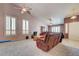 Open-concept living room with large windows, comfortable seating, ceiling fans, and tile flooring at 2301 Jean Paul Ave, North Las Vegas, NV 89031
