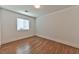 Well-lit bedroom with laminate flooring, a window with blinds, and minimalist decor at 2323 Mariposa Ave, Las Vegas, NV 89104
