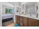 Bathroom with double vanity sinks and wood cabinets and a view to the backyard at 2421 Gamma Ray Pl, Henderson, NV 89044