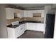 An inside view of the kitchen with a stove, sink, cabinets, and black refrigerator at 2525 Donna St # L, North Las Vegas, NV 89030