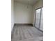Bright living room with stylish gray wood-look floors and sliding glass doors to the backyard at 2525 Donna St # L, North Las Vegas, NV 89030