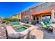 Backyard featuring a swimming pool and hot tub, covered patio, and well-maintained landscaping at 2733 Auchmull St, Henderson, NV 89044