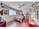 Comfortable bedroom with sports-themed decor, a ceiling fan, and a large window, offering a personal and inviting space at 2733 Auchmull St, Henderson, NV 89044