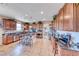 A stylish kitchen featuring wood cabinets, stainless steel appliances, and a center island with bar seating at 2733 Auchmull St, Henderson, NV 89044