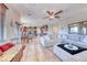 Open-concept living room featuring tile floors, ceiling fan, and plenty of natural light from large windows at 2733 Auchmull St, Henderson, NV 89044