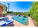 Resort-style backyard with a large pool, lounge chairs, and lush landscaping, perfect for relaxation at 2733 Auchmull St, Henderson, NV 89044