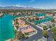 Stunning aerial view of the lakefront neighborhood with turquoise waters, lush landscaping, and mountain views at 3061 Waterside Cir, Las Vegas, NV 89117