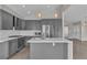 Modern kitchen featuring stainless steel appliances, gray cabinetry, subway tile backsplash, and a spacious center island at 3061 Waterside Cir, Las Vegas, NV 89117