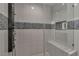 Glass shower with tiled feature wall, shower bench, and modern shower head at 3061 Waterside Cir, Las Vegas, NV 89117