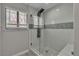 Glass shower with white tile, window, accent tile, and pebble floor at 3061 Waterside Cir, Las Vegas, NV 89117