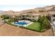 Expansive aerial view of a luxury home with a stunning pool, manicured lawn, and desert landscape at 34 Olympia Outlook Dr, Las Vegas, NV 89141