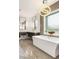 Modern bathroom featuring a soaking tub, contemporary lighting, and stylish vanity with large mirrors at 34 Olympia Outlook Dr, Las Vegas, NV 89141