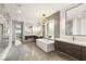 Bright bathroom featuring a freestanding tub, glass shower, and dual vanities with sleek modern design at 34 Olympia Outlook Dr, Las Vegas, NV 89141