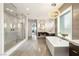 Luxurious bathroom featuring a modern tub, walk-in shower, dual sinks and vanity areas and large window at 34 Olympia Outlook Dr, Las Vegas, NV 89141