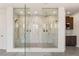 Luxurious bathroom showcasing a spacious glass shower, dual showerheads, and sleek marble-style tiling at 34 Olympia Outlook Dr, Las Vegas, NV 89141