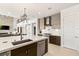 Modern kitchen with stainless steel appliances and stylish lighting fixtures, seamlessly connects to the living space at 34 Olympia Outlook Dr, Las Vegas, NV 89141