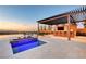 An outdoor kitchen and bar area with a pool and a fire pit provides an ideal space for entertaining at 34 Olympia Outlook Dr, Las Vegas, NV 89141