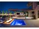 Outdoor space with a kitchen and fire pit next to a pool, perfect for evening gatherings with ambient lighting at 34 Olympia Outlook Dr, Las Vegas, NV 89141