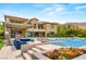 Beautiful pool area with a fire pit, outdoor kitchen, and comfortable blue seating at 34 Olympia Outlook Dr, Las Vegas, NV 89141