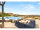 A luxurious outdoor space featuring a pool, an elegant fire pit, and a cozy seating area with mountain views at 34 Olympia Outlook Dr, Las Vegas, NV 89141