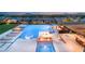 An luxurious backyard features a stunning pool with fire features, lounge chairs, and an outdoor kitchen with city views at 34 Olympia Outlook Dr, Las Vegas, NV 89141