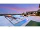 The large pool has lounge chairs and fire features, alongside an outdoor kitchen, and lush lawn for ultimate outdoor enjoyment at 34 Olympia Outlook Dr, Las Vegas, NV 89141
