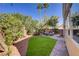 Landscaped backyard featuring a lush lawn, a desert garden, and an inviting outdoor seating area at 3420 Lockport St, Las Vegas, NV 89129