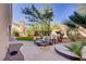 Backyard featuring a patio area, manicured lawn, and mature trees for privacy at 3420 Lockport St, Las Vegas, NV 89129
