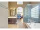 Luxurious bathroom with bathtub, glass shower, and view into the main bedroom at 3420 Lockport St, Las Vegas, NV 89129