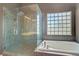 Modern bathroom featuring a glass shower and a soaking tub near a glass block window at 3420 Lockport St, Las Vegas, NV 89129