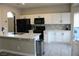Bright kitchen with white cabinets, stainless steel appliances, gray backsplash, and hardwood floors at 3524 Silver Lantern Dr, North Las Vegas, NV 89032