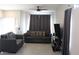 Cozy living room with a ceiling fan, gray sofa, dark gray curtains, and hardwood flooring at 3524 Silver Lantern Dr, North Las Vegas, NV 89032