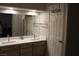 Bathroom with double sinks, a large mirror, and modern fixtures, with a view to the water closet at 3524 Silver Lantern Dr, North Las Vegas, NV 89032