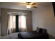 Inviting bedroom with a ceiling fan, large window, neutral color scheme, and carpeted flooring at 3524 Silver Lantern Dr, North Las Vegas, NV 89032