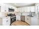 Kitchen with modern appliances, white cabinetry, stainless steel dishwasher, and light countertops at 416 Greenbrook St, Las Vegas, NV 89110