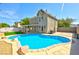 Inviting in-ground pool surrounded by a brick border, artificial grass, and desert landscaping at 416 Greenbrook St, Las Vegas, NV 89110