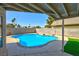 This beautiful backyard features a pool with surrounding stone, an outdoor covering, and artificial grass at 416 Greenbrook St, Las Vegas, NV 89110