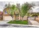Charming two-story home with well-manicured lawn, driveway to side gate and mature trees in front yard at 421 Raindance Dr, Henderson, NV 89014